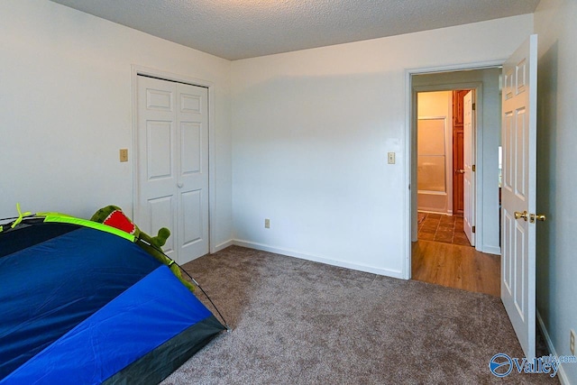 carpeted bedroom featuring a closet and a textured ceiling