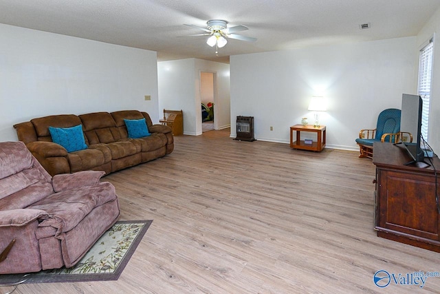 living room with ceiling fan, a textured ceiling, and light hardwood / wood-style floors