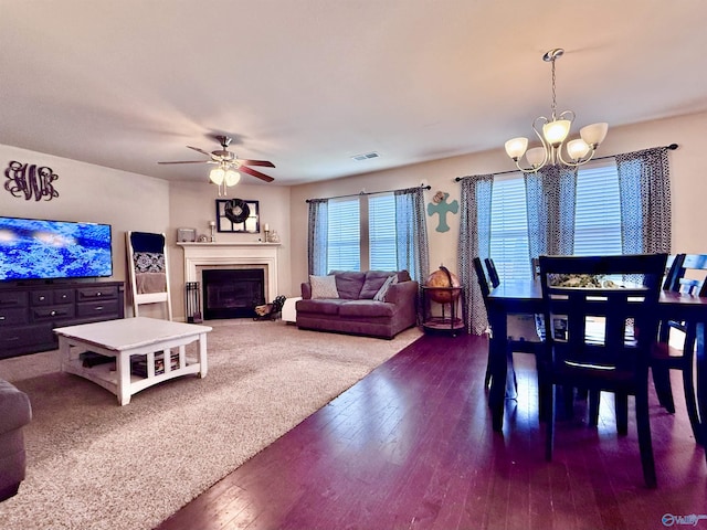 dining room with dark wood-type flooring and ceiling fan with notable chandelier