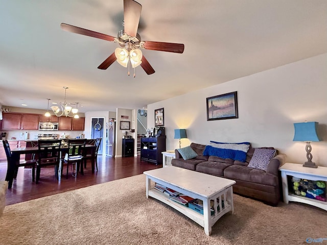 living room featuring ceiling fan with notable chandelier