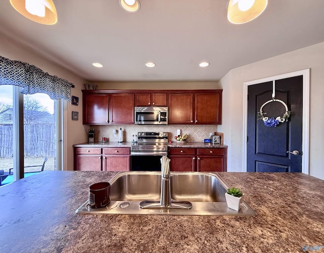 kitchen featuring appliances with stainless steel finishes, sink, and decorative backsplash