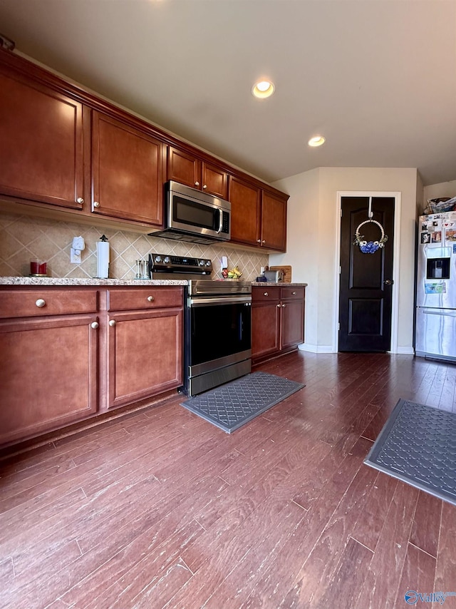 kitchen with stainless steel appliances, light stone countertops, dark wood-type flooring, and decorative backsplash