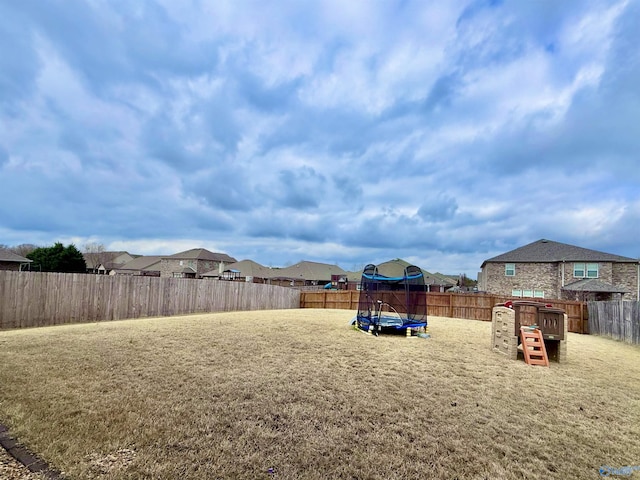 view of yard with a playground and a trampoline