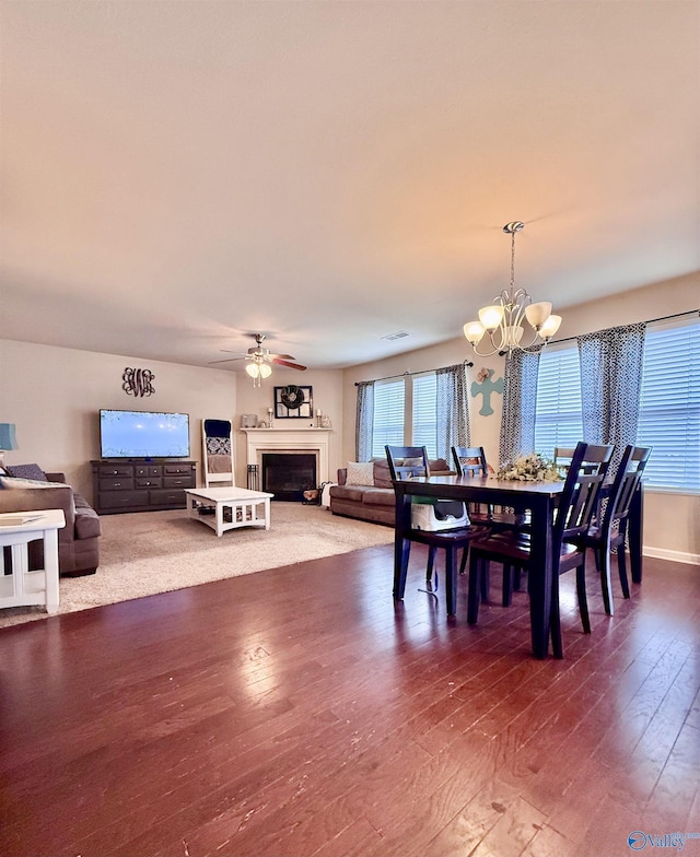 dining space with wood-type flooring and ceiling fan with notable chandelier