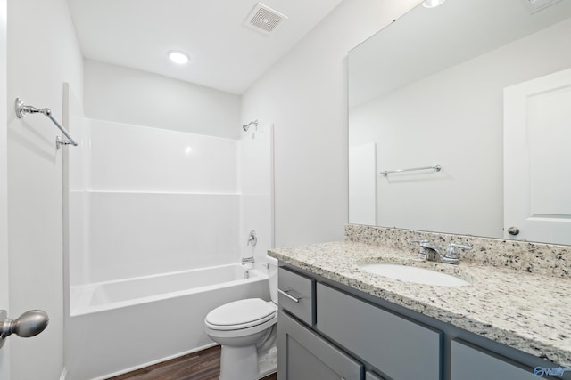 full bathroom featuring vanity, hardwood / wood-style flooring, shower / washtub combination, and toilet