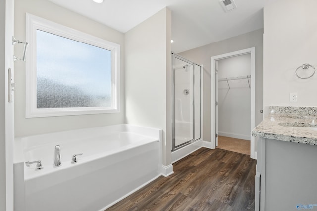 bathroom featuring plus walk in shower, hardwood / wood-style floors, and vanity