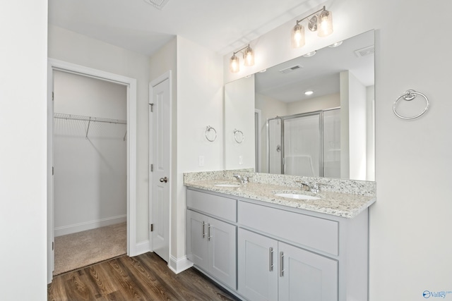 bathroom featuring a shower with door, wood-type flooring, and vanity