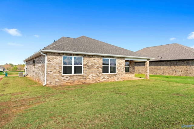 back of property with a yard and central AC unit