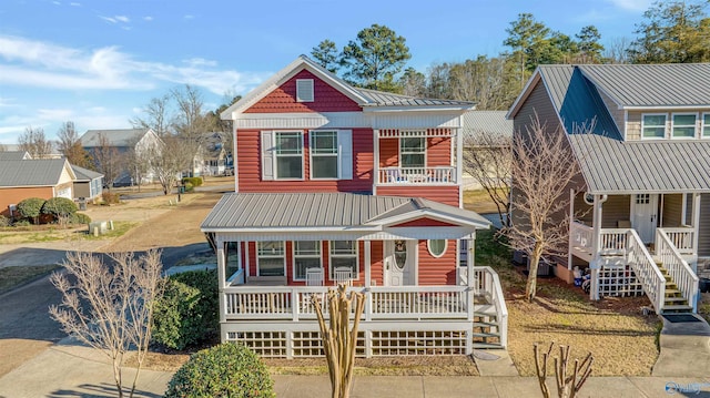 view of front of property featuring metal roof, a balcony, and covered porch