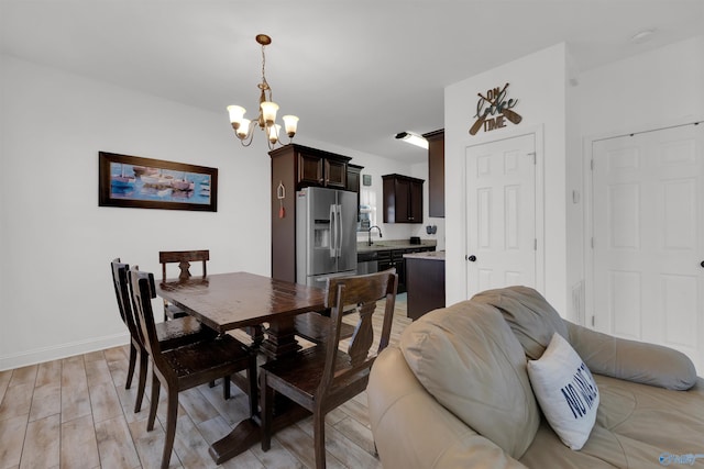 dining space featuring a notable chandelier, baseboards, and wood finish floors