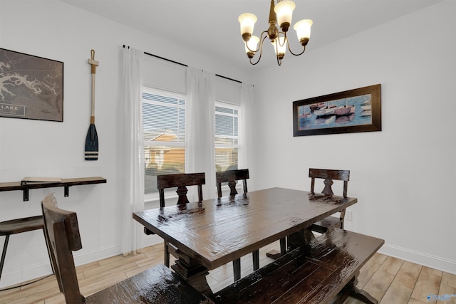 dining area with baseboards, a notable chandelier, and wood tiled floor