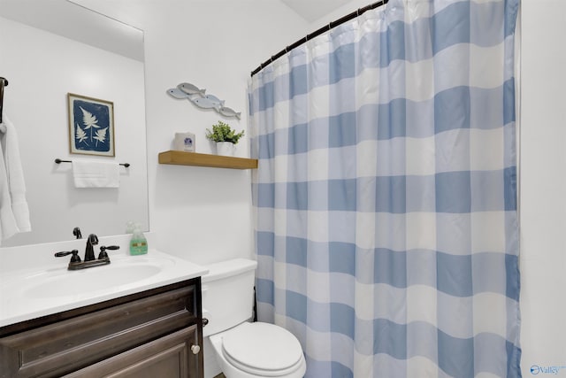 bathroom featuring toilet, curtained shower, and vanity