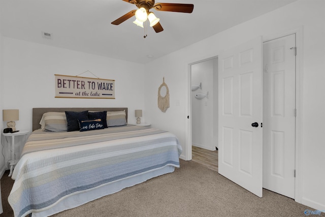 carpeted bedroom featuring visible vents and a ceiling fan