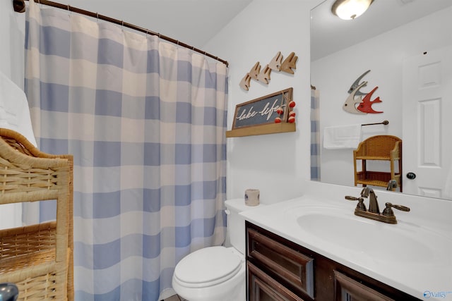 full bathroom with vanity, a shower with shower curtain, and toilet