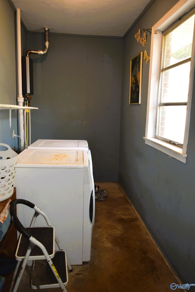 washroom with washing machine and dryer, plenty of natural light, ornamental molding, and laundry area