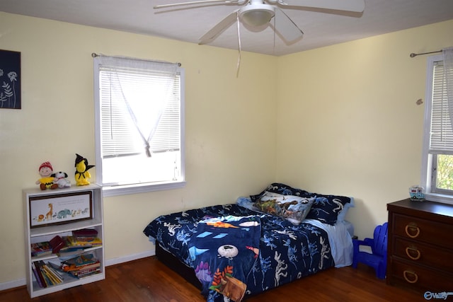 bedroom featuring baseboards, wood finished floors, and ceiling fan
