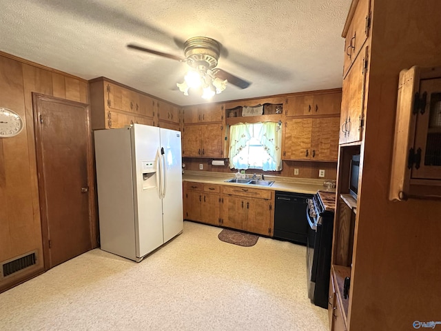 kitchen featuring brown cabinets, black dishwasher, visible vents, a sink, and white fridge with ice dispenser