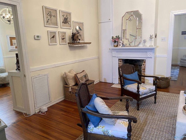 702 Mckinley Ave, Huntsville, AL 35801 - living area featuring wood finished floors, a chandelier, a fireplace, and baseboards