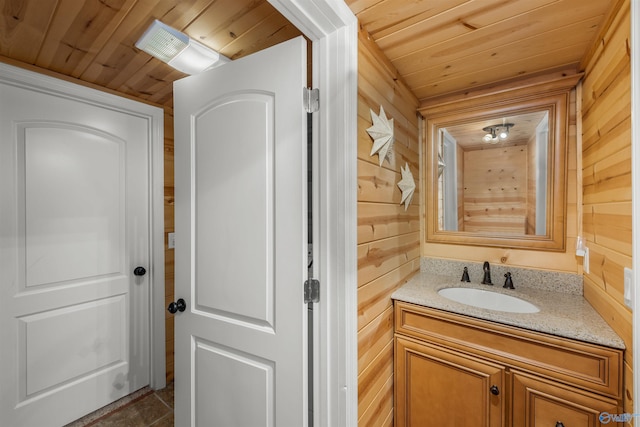 bathroom featuring wood ceiling, wooden walls, and vanity