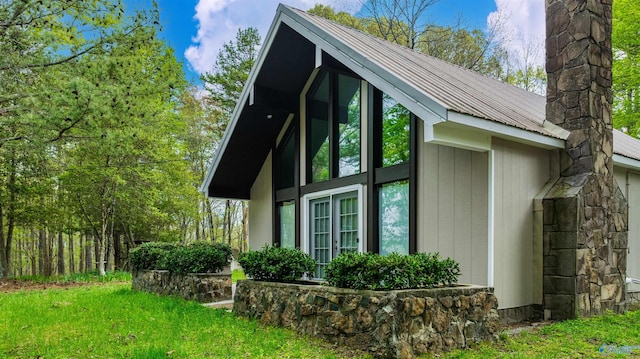 view of home's exterior featuring metal roof and a yard