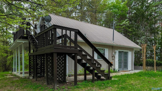 rear view of house featuring metal roof and stairway