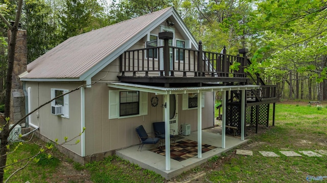 rear view of house featuring cooling unit, a patio area, metal roof, and a wooden deck