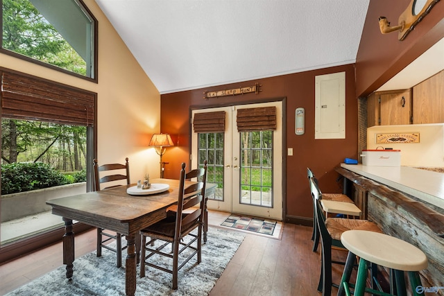 dining room featuring hardwood / wood-style flooring, electric panel, high vaulted ceiling, and french doors