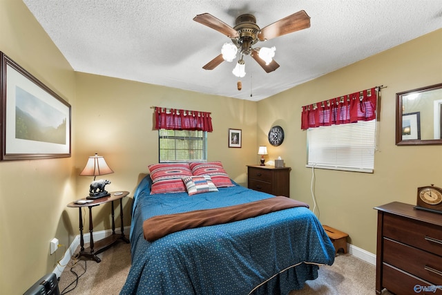 carpeted bedroom featuring ceiling fan, baseboards, and a textured ceiling