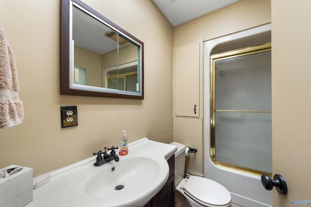 full bathroom featuring enclosed tub / shower combo, vanity, and toilet