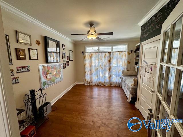 interior space with ornamental molding, ceiling fan, and dark hardwood / wood-style flooring