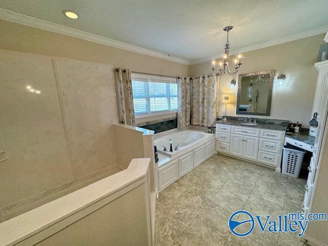 bathroom with crown molding, a notable chandelier, vanity, and a tub