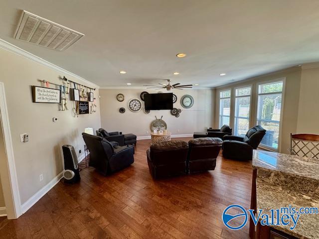 living room featuring ornamental molding, dark wood-type flooring, and ceiling fan