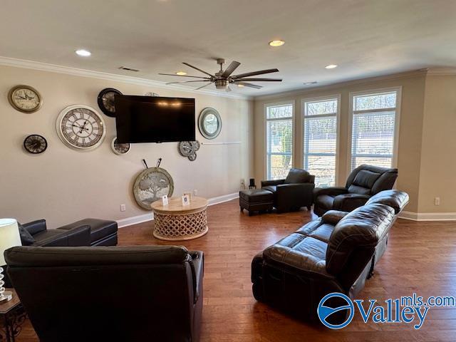 living room with hardwood / wood-style flooring, ornamental molding, and ceiling fan