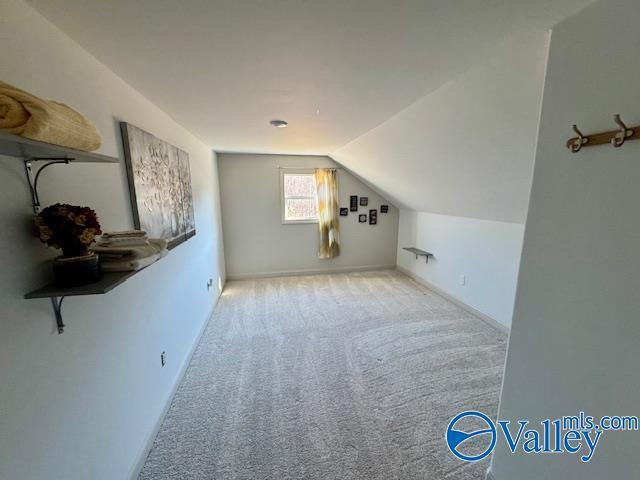 bonus room featuring lofted ceiling and light colored carpet