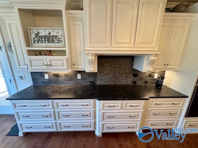 kitchen featuring dark hardwood / wood-style flooring, decorative backsplash, and white cabinets