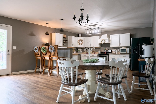 dining room with baseboards, a notable chandelier, and light wood-style flooring