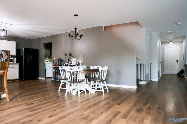 dining room with an inviting chandelier, baseboards, washer / clothes dryer, and wood finished floors