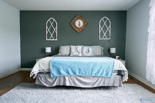 bedroom with baseboards and wood finished floors