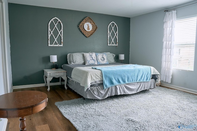 bedroom with baseboards and wood finished floors