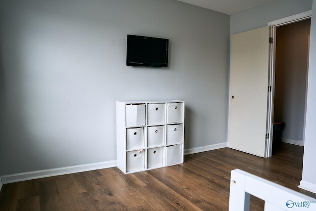 unfurnished bedroom featuring baseboards and dark wood-style floors