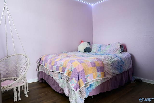 bedroom featuring baseboards and wood finished floors