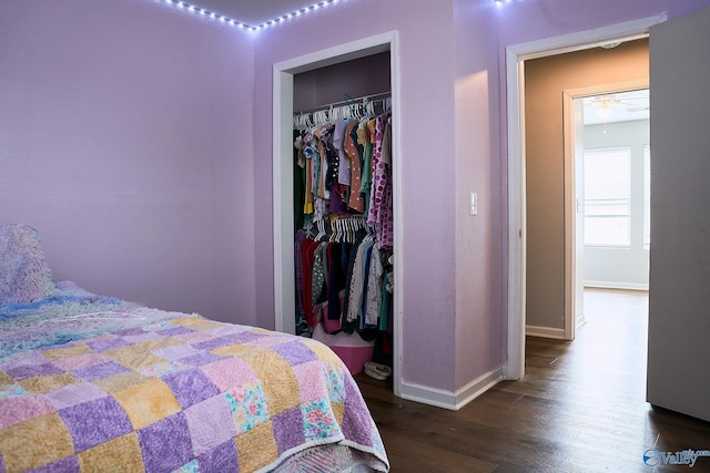 bedroom with baseboards, a closet, and dark wood-type flooring