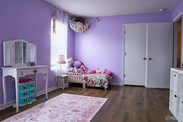 bedroom featuring baseboards and wood finished floors