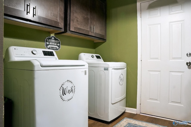 clothes washing area with cabinet space, baseboards, dark wood-type flooring, and washing machine and clothes dryer