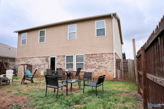 back of house featuring a fenced backyard and brick siding