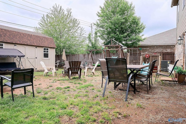 view of yard featuring an outdoor structure, fence, and a storage shed