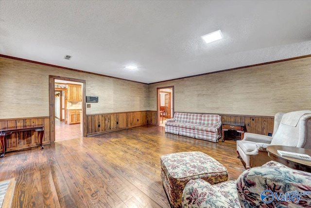 living room featuring wood walls, hardwood / wood-style flooring, and a textured ceiling