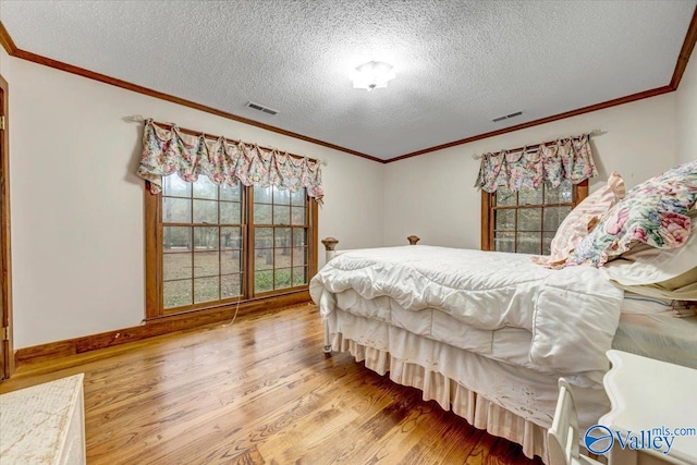 bedroom featuring wood-type flooring, crown molding, and a textured ceiling