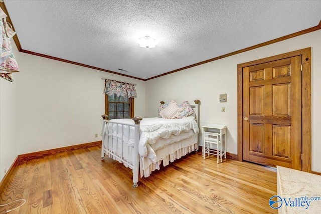 bedroom with light hardwood / wood-style floors, a textured ceiling, and ornamental molding