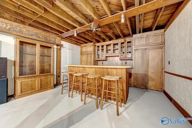 kitchen with kitchen peninsula, a breakfast bar area, and ceiling fan